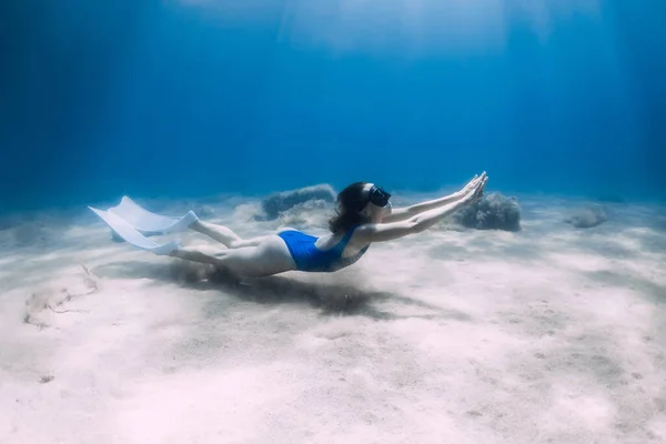フィンを持つ女性のフリーダイバーは 日光と海の中で水中で滑空 夏のフリーダイビング — ストック写真