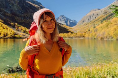 Sonbahar mevsiminde dağlarda yürüyüş yapan mutlu kadın..