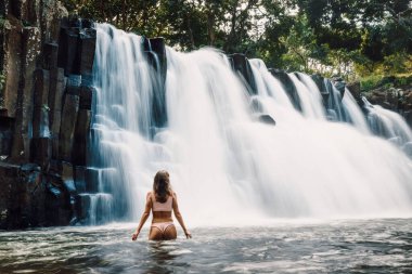 Rochester Falls waterfall and woman in bikini. Amazing cascade waterfall in Mauritius