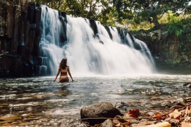 Rochester Falls waterfall and woman in bikini. Amazing cascade waterfall in Mauritius