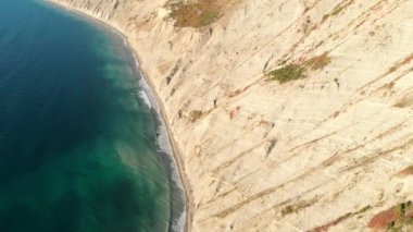 Uçurumlu kayalık kıyı ve dalgalı mavi deniz manzarası