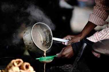 Tüccarlar çay kaynatıyor ve atıkları filtreliyor..