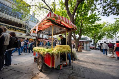 İstanbul / Türkiye - 02 Mayıs 2019: Kaynamış mısır satan araba tezgahı Tüccar, kentteki Büyük Pazar 'ın önündeki büyük bir ağacın altında genç bir adam.