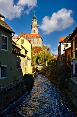 Cesky Krumlov Şato Kulesi sonbahar renkleri, açık mavi gökyüzü ve güzel bulutlarla dolu bir öğleden sonra, Avrupa 'nın eski kenti ve dünya mirası turistler arasında ünlü ve popülerdir..