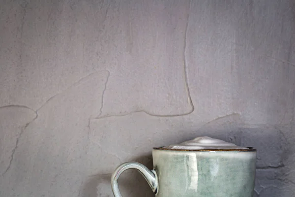 Κεραμική κούπα με λευκό αφρό γκρι φυσικό σχεδιασμό πέτρας με σκυρόδεμα φόντο τοίχο, καφέ ή τσάι έννοια, αντίγραφο χώρου — Φωτογραφία Αρχείου