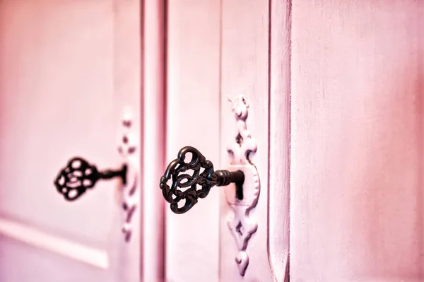 Рожеві старовинні антикварні двері зі старими ключами від скелета в зафіксованій текстурі дерев'яного фону, ретро дизайн — стокове фото