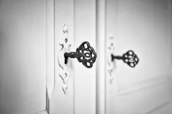 Старі старовинні двері з антикварними ключами скелета в замку, ретро фонова текстура чорно-біла — стокове фото