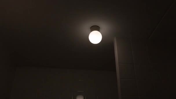 4k colpo tremolante vecchia plafoniera nella stanza buia, lampadina sul soffitto di una casa — Video Stock