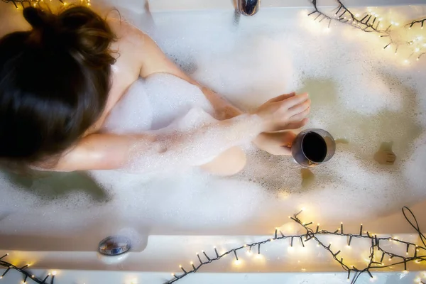 Jovens mulheres mão segurando copo de vinho na banheira, beber vinho tinto e deitado na banheira com espuma de bolha, vista superior, relaxamento e conceito de spa — Fotografia de Stock