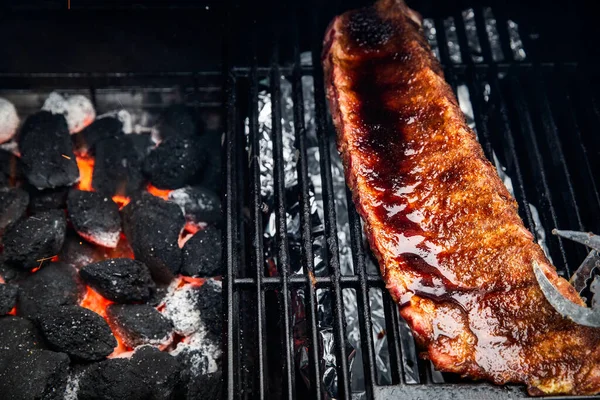 Närbild av BBQ Roast och rökt fläsk Spareribs glaserade med sås på The Hot Charcoal Grill med lågor, Grill och hobby koncept — Stockfoto