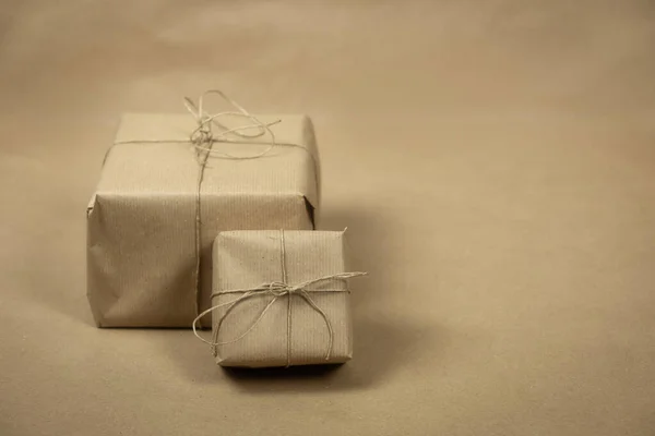 Два подарочных пакета, обернутые простой коричневой бумагой и веревкой и коричневой бумагой фоновой текстуры, ретро подарочная коробка. нынешняя концепция — стоковое фото