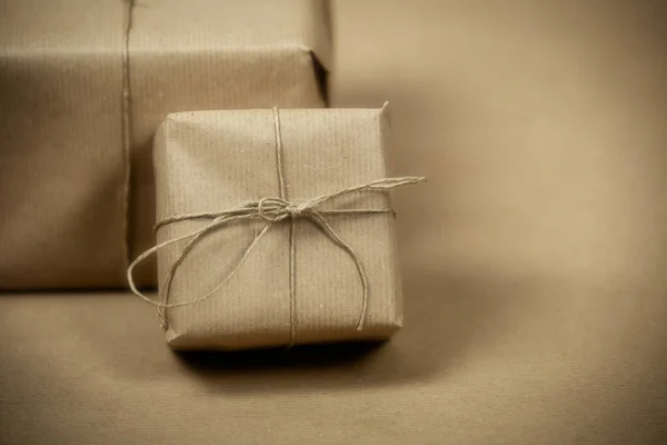 Два подарочных пакета, обернутые простой коричневой бумагой и веревкой и коричневой бумагой фоновой текстуры, ретро подарочная коробка. нынешняя концепция — стоковое фото