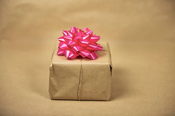 Бурый обычная бумага подарочная коробка с розовой упаковки украшения на коричневом фоне, подарок и день рождения концепции, ретро-дизайн — стоковое фото