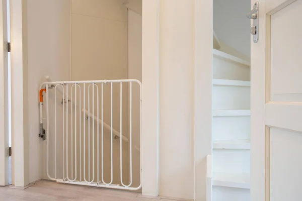 Puerta protectora blanca de la escalera de seguridad del bebé en la escalera del pasillo casa nueva moderna, cerca para los niños en el hogar hermoso — Foto de Stock