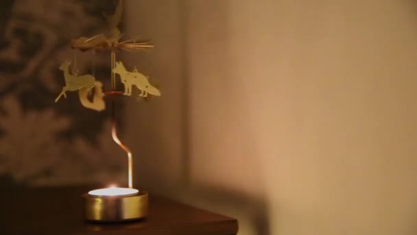 Спінінговий золотий тримач з біговими лісовими тваринами, вінтажний обертовий свічковий світло в темряві з розмитим фоном — стокове відео