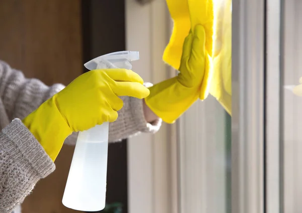 用喷雾清洁剂、黄色橡胶手套和洗碗布清洗窗户关于工作表面概念的卫生、商业和健康概念 — 图库照片