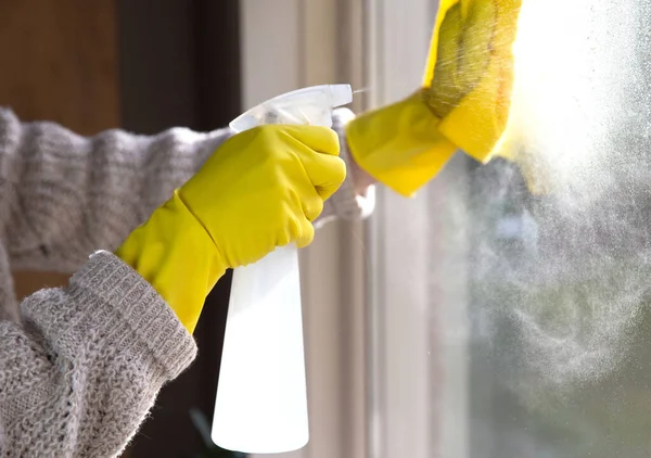 Čištění okna čisticím prostředkem, žlutými gumovými rukavicemi a hadříky na pracovní ploše pro hygienickou, obchodní a zdravotní koncepci — Stock fotografie