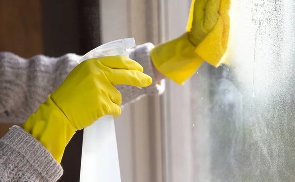 Cleaning a window with spray detergent, Yellow rubber gloves and dish cloth on work surface concept for hygiene, business and health concept — Stock Photo, Image