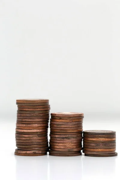 Sidovy av staplar av mynt ökar i höjd, på vit studio bakgrund isolerad, affärer och finansiella koncept — Stockfoto