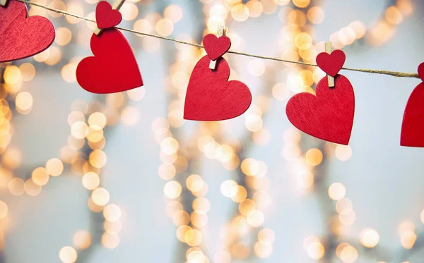 Joyeux fond Saint-Valentin avec des cœurs rouges suspendus avec une pince à linge sur une corde avec fond bokeh, design romantique, carte de vœux ou espace de copie — Photo