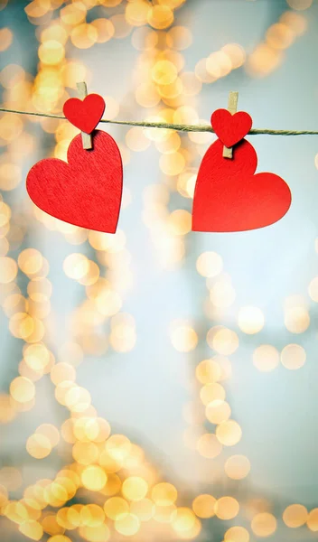 Feliz día de San Valentín fondo con corazones rojos cuelgan con pinza de ropa en la cuerda con fondo bokeh, diseño romántico, tarjeta de felicitación o espacio de copia — Foto de Stock