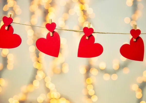 Fundal fericit Ziua Îndrăgostiților cu inimi roșii atârnă cu îmbrăcăminte pe frânghie cu fundal bokeh, design romantic, felicitare sau spațiu de copiere — Fotografie, imagine de stoc