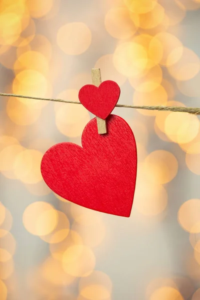 Feliz día de San Valentín fondo con corazones rojos cuelgan con pinza de ropa en la cuerda con fondo bokeh, diseño romántico, tarjeta de felicitación o espacio de copia — Foto de Stock