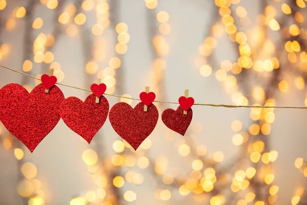Joyeux fond Saint-Valentin avec des cœurs rouges suspendus avec une pince à linge sur une corde avec fond bokeh, design romantique, carte de vœux ou espace de copie — Photo