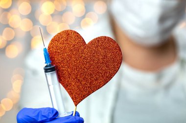 Doktor, hemşire, bilim adamı, mavi eldivenli araştırmacı. Grip, kızamık, koronavirüs, kovid-19 aşısı, kalp sembollü insan klinik deneyleri aşısı hazırlığı.