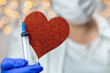 Doktor, hemşire, bilim adamı, mavi eldivenli araştırmacı. Grip, kızamık, koronavirüs, kovid-19 aşısı, kalp sembollü insan klinik deneyleri aşısı hazırlığı.