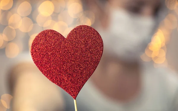 Young Female holding sparkling red heart wearing white protective medical mask for coronavirus, Covid-19 and Valentines day, Healht concept — Stock Photo, Image