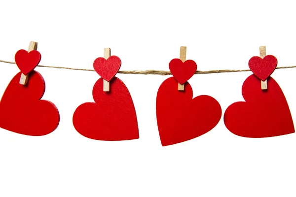 Röda hjärtan med klädnypor hängande med rep isolerad på vit bakgrund. Alla hjärtans dag, Sjukvård, Mors dag koncept, kopiera utrymme — Stockfoto