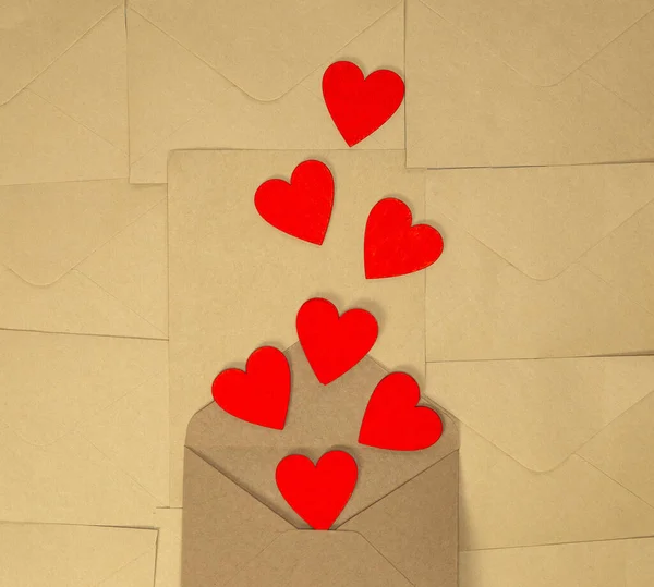 Sevgililer Günü zarfı, üzerinde kırmızı kalpler olan kahverengi kağıt kaplama, romantik aşk tasarımı üst görünüm, kopyalama alanı. — Stok fotoğraf