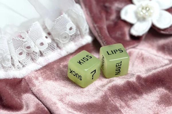 Dois dados para jogo sexual erótico com o texto beijar lábios e pescoço no fundo tecido de cetim rosa, Dia dos Namorados, Amor, Conceito de sexo — Fotografia de Stock