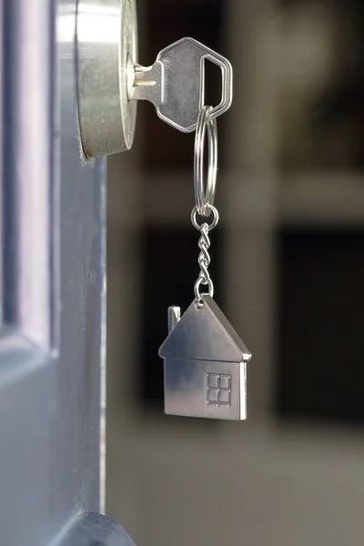 Buka pintu ke rumah baru dengan kunci dan rantai kunci berbentuk rumah. Hipotek, investasi, real estate, properti dan konsep rumah baru — Stok Foto