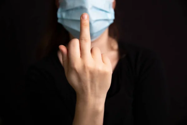 Levante el dedo medio para Coronavirus, Mujer con máscara médica protectora para Covid-19 fondo oscuro, Concepto para Corona y salud, Stop Covid —  Fotos de Stock