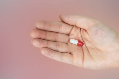 Beyaz arka planda ilaç, vitamin ya da uyuşturucu için kırmızı ve beyaz kapsülleri tutan eller. Üst Manzara. Düz yatıyordu. Uzayı kopyala Kapatın. Tıp, iş ve sağlık kavramı