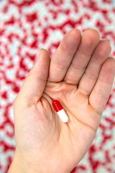 hands holding red and white capsules for medication, vitamin or drugs background on white background. Top view. Flat lay. Copy space. Close up. Medicine,business and health concept