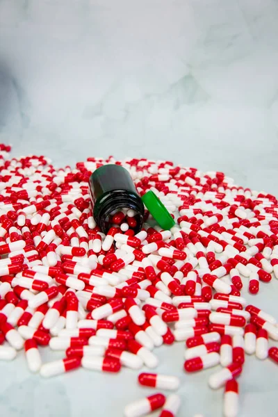 Botol dengan kapsul merah dan putih dengan latar belakang putih, vitamin, obat-obatan atau latar belakang obat-obatan, kesehatan, medis dan konsep bisnis — Stok Foto