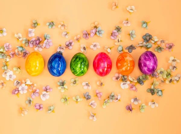 Coloridos huevos de Pascua casero pintado plano vista superior sobre pastel naranja melocotón fondo brillante diseño fresco, Feliz Pascua, concepto de primavera — Foto de Stock