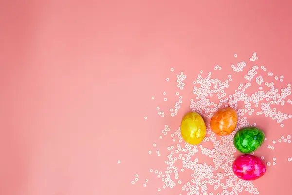 Barevné malované velikonoční vajíčka na pastelově růžové pozadí s růžovými květy horní pohled, Flay ležel moderní design Kopírovat prostor, jaro, Veselé Velikonoce koncept jasné čerstvé barvy — Stock fotografie