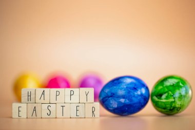 Pastel renkli turuncu arka plan ve soluk paskalya yumurtaları, parlak taze renkler, bahar, Paskalya tatili, fotokopi alanı olan tebrik kartı konsepti