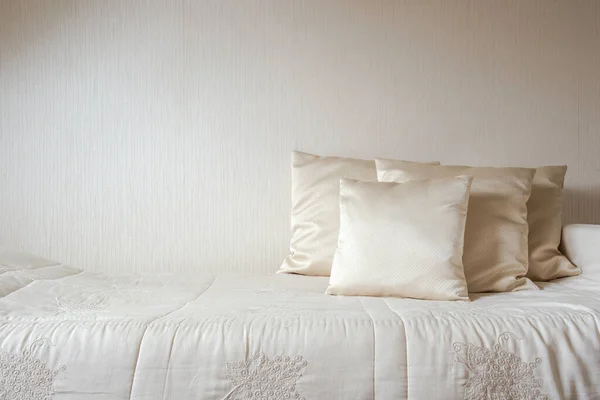 Almohada de seda y manta contra la pared de color crema en el dormitorio de estilo moderno y lujoso, decoración moderna, diseño, espacio de copia de concepto de arquitectura — Foto de Stock