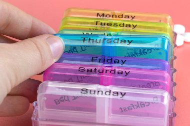 Hap kutusu hatırlatıcısı, el hapları pembe arka planda renkli kutularda günlük ilaçlar, yaşlılar, yaşlılar, iş dünyası, sağlık, ilaç konsepti modern tasarım