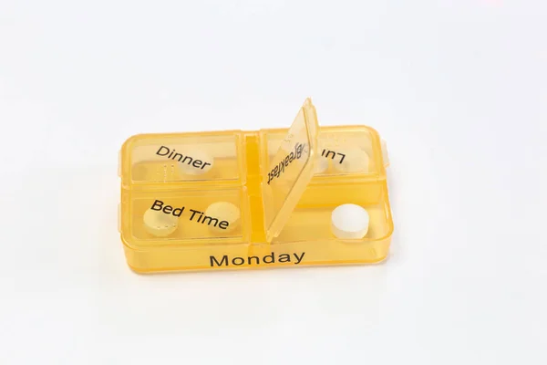 Tangan manusia dengan kotak pengingat pil, mengambil obat yang terisolasi pada latar belakang putih, kotak pengatur pil untuk hari senin — Stok Foto