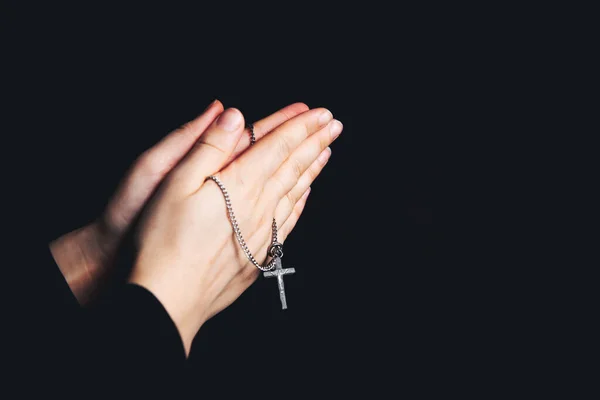 Orando mãos segurando um rosário, Closeup segurando colar com cruz, orar por Deus no escuro, símbolo cristão religioso — Fotografia de Stock