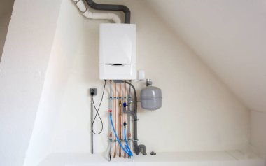Yeni gaz kazanı, bakır boruları, vanaları ve diğer ekipmanları olan ısıtma sistemi kazan dairesi gaz ısıtıcısı sistemi, yeni evin beyaz duvarında modern.