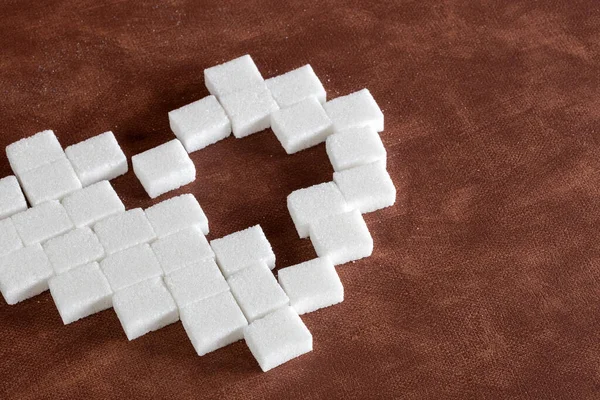 Słodkie serce wykonane z kostek cukru na brązowym naturalnym tle tekstury, miłość, słodycze, cukierki, cukier, koncepcja żywności nowoczesny design — Zdjęcie stockowe