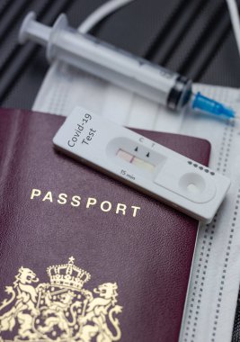 COVID-19, seyahat ve tecrit konsepti Covid-19 hızlı test ve Coronavirus aşısı için şırınga içeren pasaport. Seyahat gereksinimi uçuyor