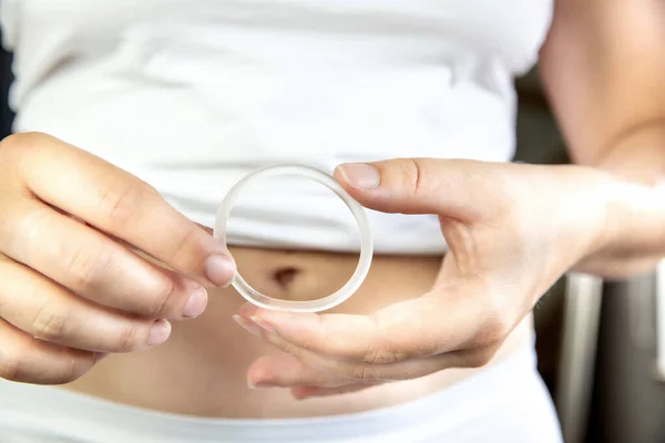 Controle de natalidade, hormônio, anel de contracepção em uma mão feminina roupa interior branca e barriga, anel vaginal para uso contraceptivo com espaço de cópia — Fotografia de Stock